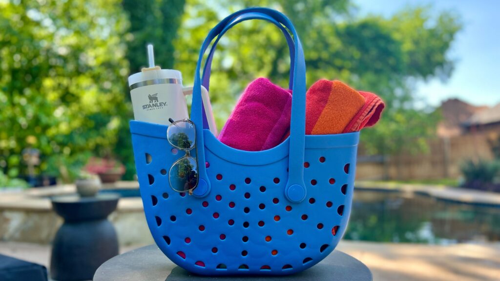 beach bag blue with towels and sunglasses by the pool