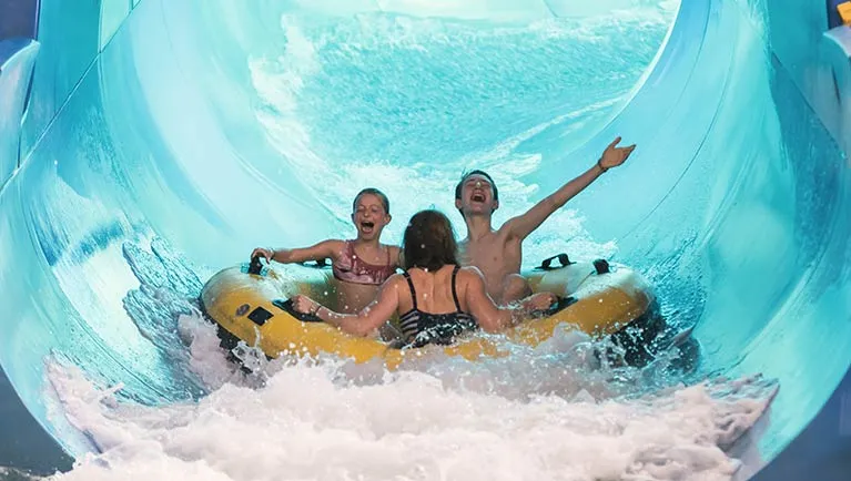 great wolf lodge raft with people in it going down slide