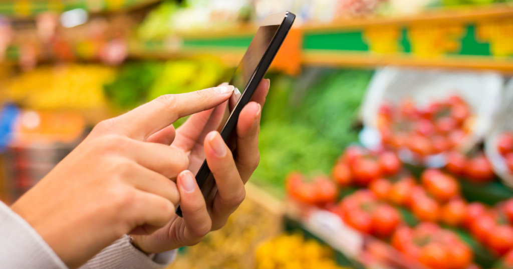 lady's hands using phone in grocery store