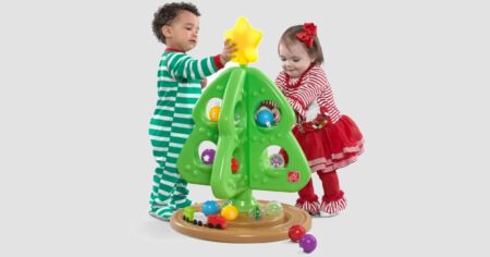 two kids playing with a toy Christmas tree