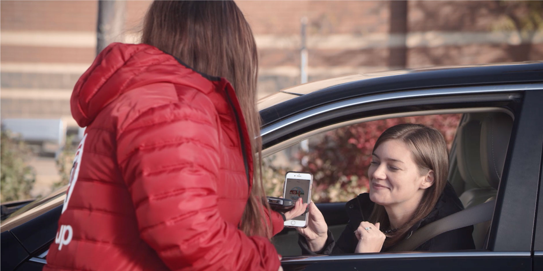 Target employee scanning a womans phone while she is in her car