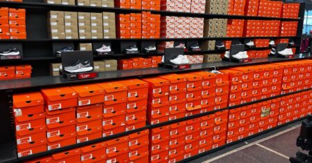 Wall display of Adidas & Nike Shoes & Orange Nike Shoe Boxes at Dick's Sporting Goods During Shoe Clearance Promotion