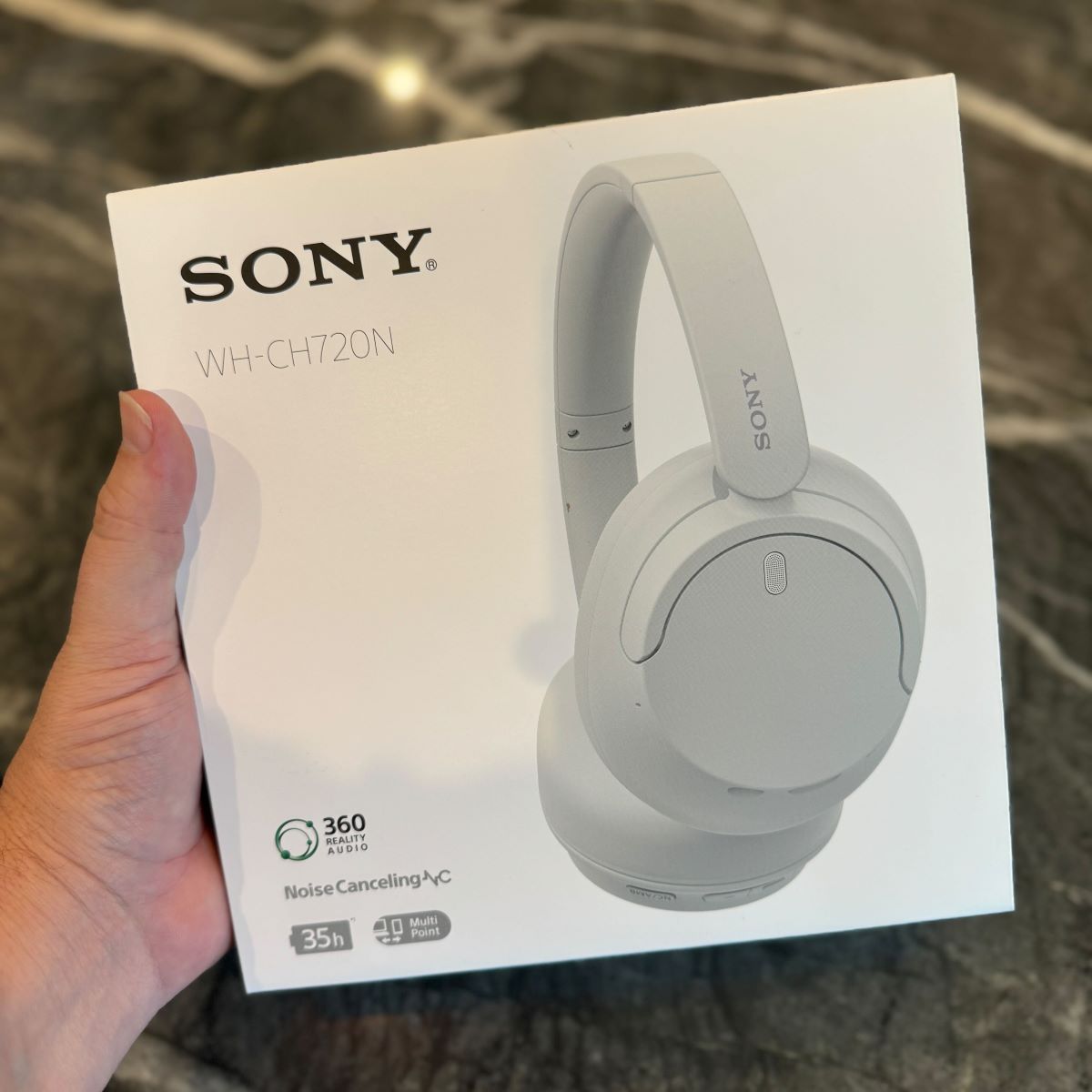 hand holding a Sony headphones box