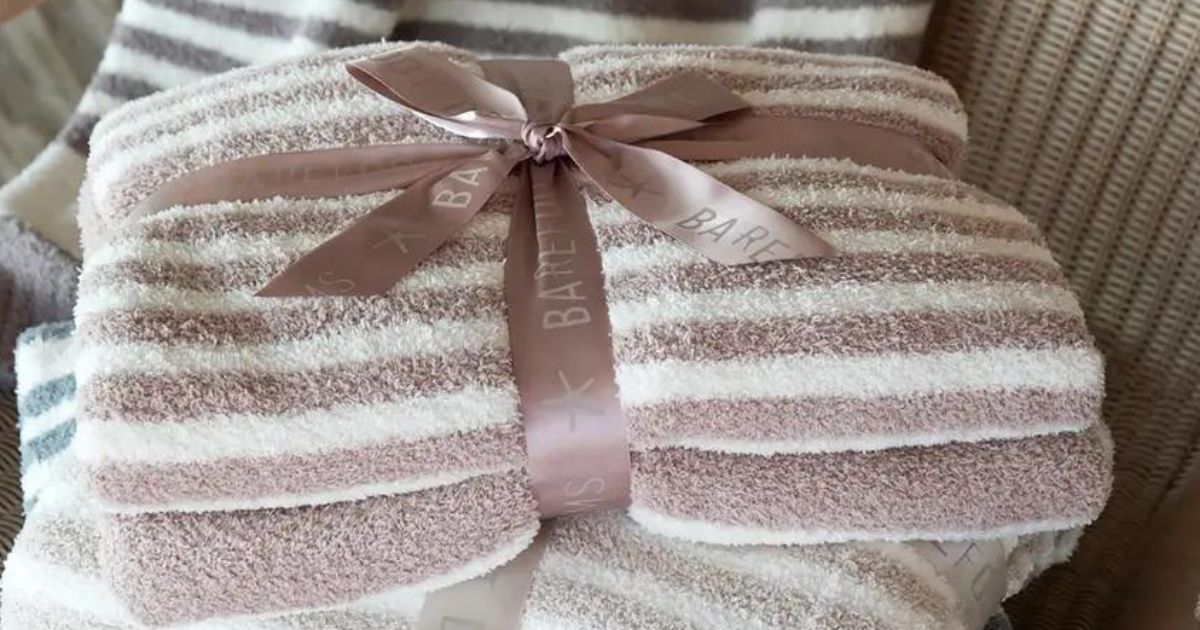 pink striped blanket folded up with a bow on it