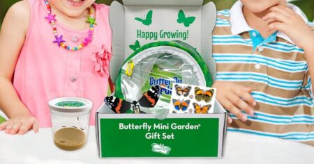 two kids sitting with a box of butterfly garden supplies