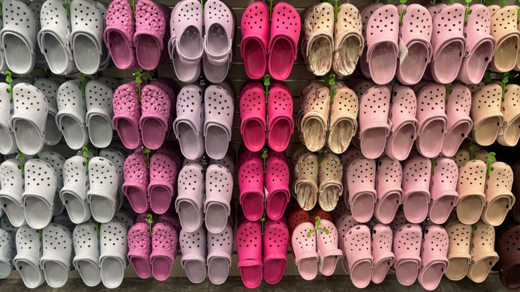 display of crocs hanging on wall with multiple color options