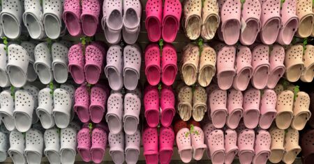 display of crocs hanging on wall with multiple color options
