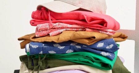 stack of folded clothing with a hat on the top