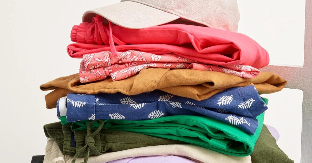 stack of folded clothing with a hat on the top