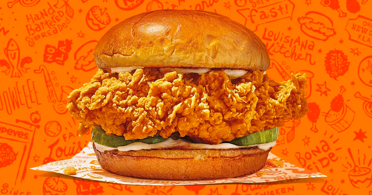 popeyes chicken sandwich with orange background