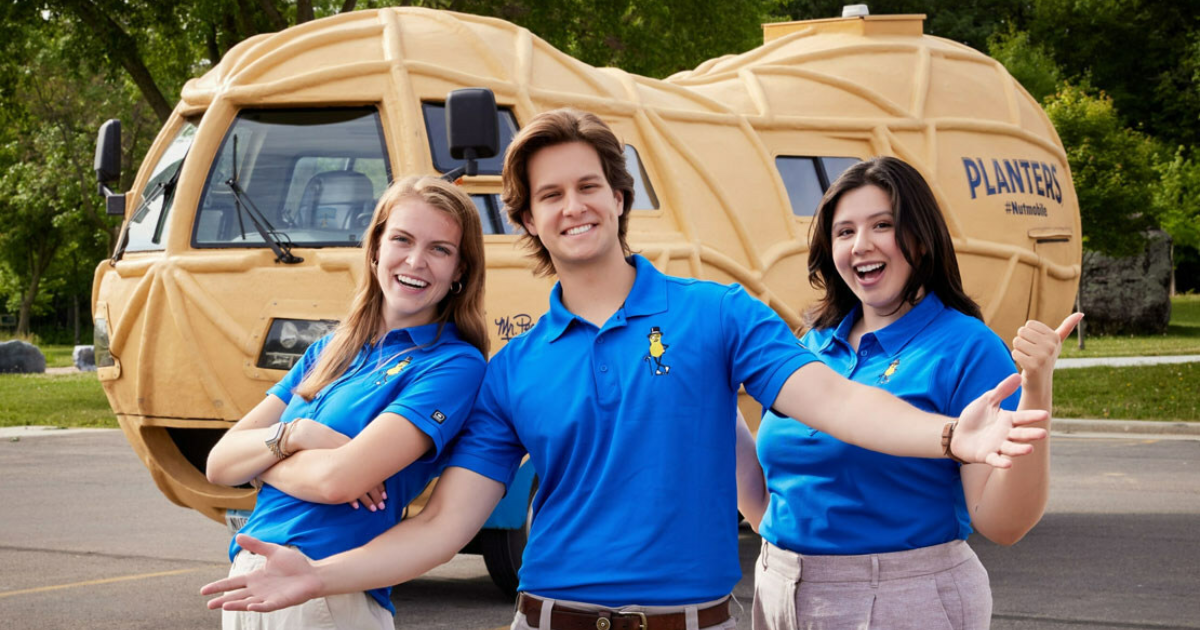 Three people standing in front of the PLANTERS NUTmobile