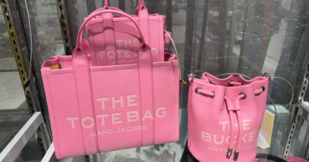 pink marc jacobs the tote bags sitting on a shelf