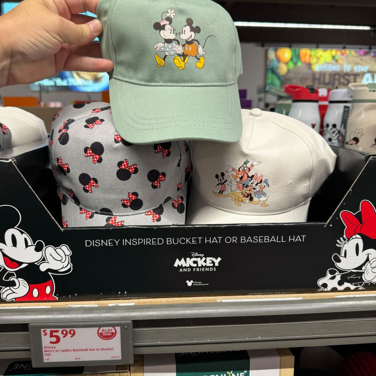 hand holding a hat with Mickey and Minnie Mouse on it
