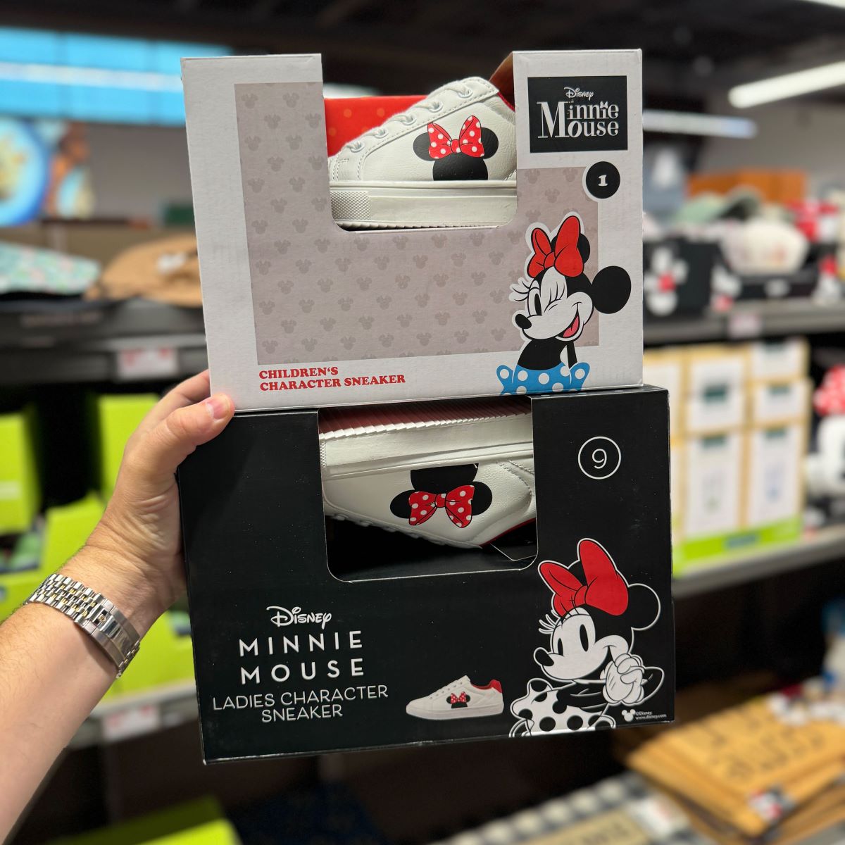 hand holding two boxes of Disney shoes