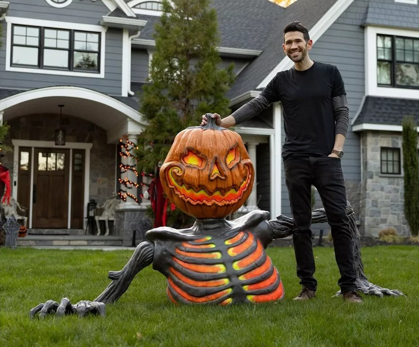 Embers the Pumpkin Skeleton Black Light Reactive Ground Breaker ft man standing next to a pumpkin skeleton