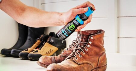 hand holding FunkAway spray by boots