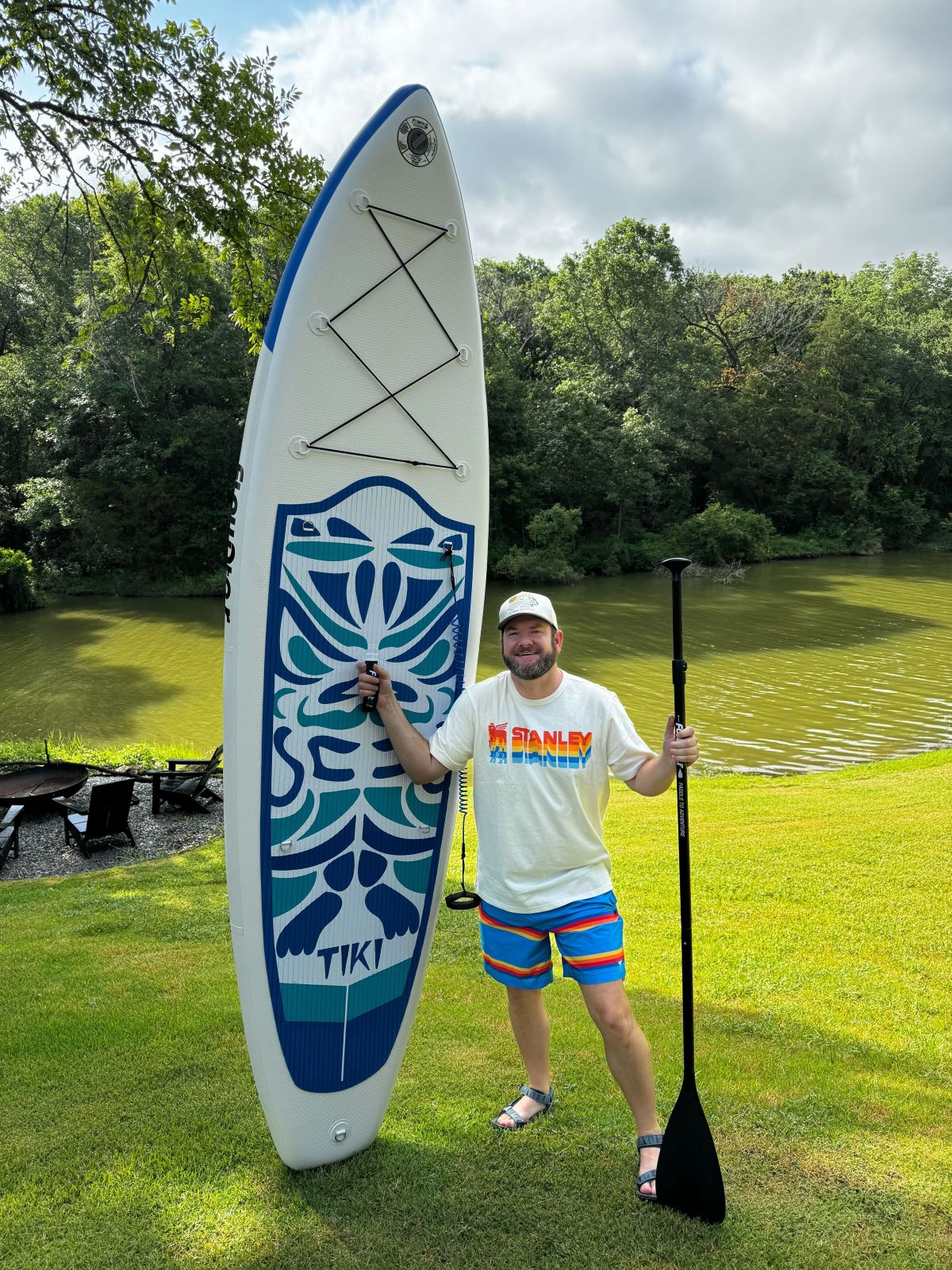 man standing next to a paddle board