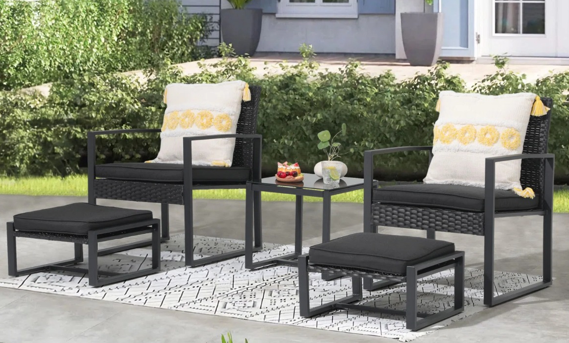 two black patio chairs with ottomans