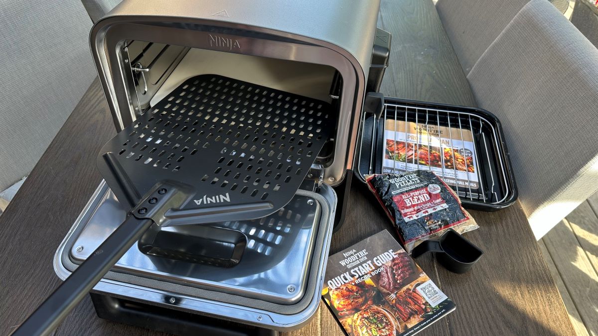 Ninja Oven Ninja oven with a pizza peel on the lid and cookbook next to it