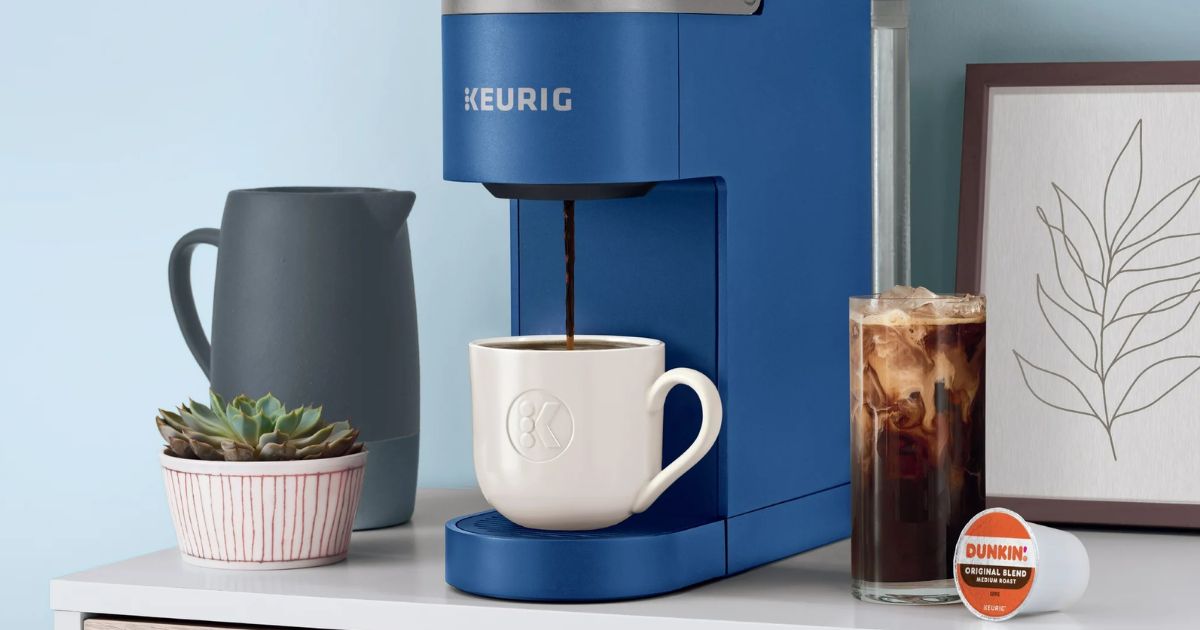 Keurig Iced Coffee Maker Keurig coffee maker with a mug under it and a cup of coffee next to it