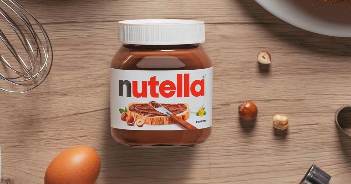 Nutella jar of Nutella with hazelnuts by it