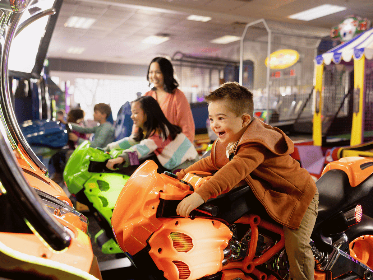 Chuck E Cheese Kids playing on arcades