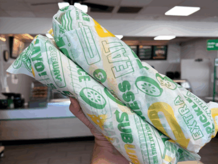 Kendall holding Two Footlong Sandwiches at Subway