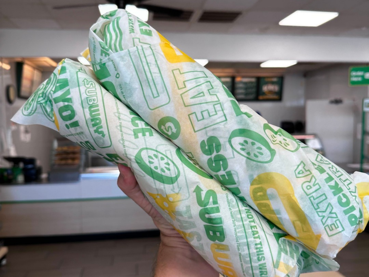 Kendall holding Two Footlong Sandwiches at Subway